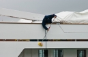 Deckhand cleaning the superstructure aboard a large yacht