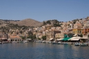 Picturesque houses and shops in Symi harbour, Gialos,  from the sea