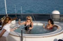 Aoife Mulhall serves champagne to Elizabeth Flemming and Ceyni Pedersen enjoying the jacuzzi on the sun deck