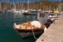 Small boat ready to take water and tomatos out to boats at anchor on the dock in Gocek